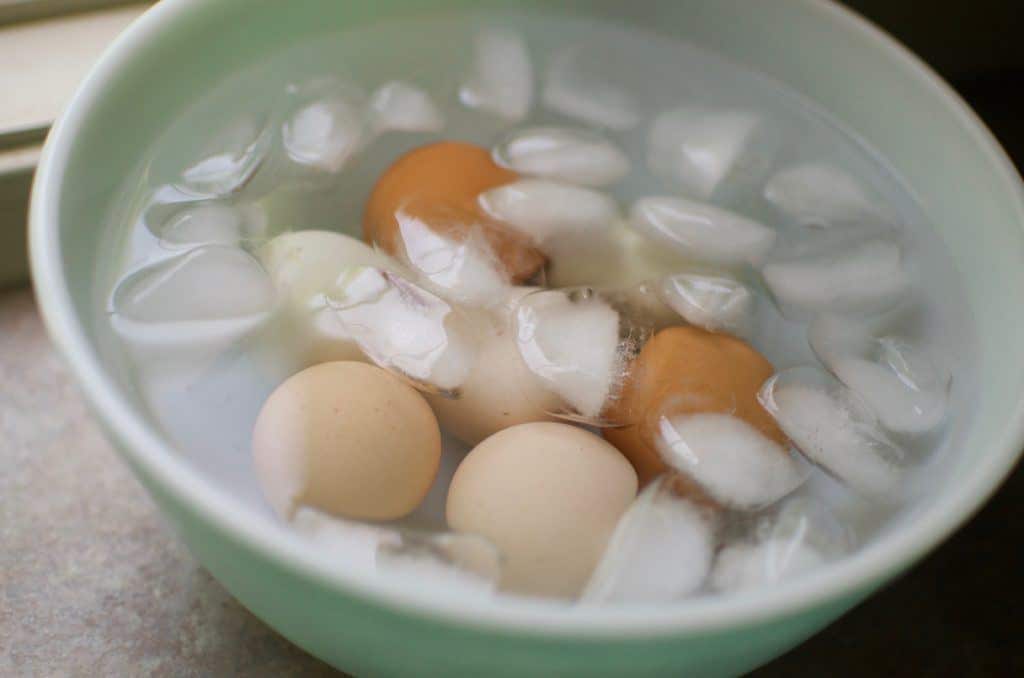 Cooked eggs cooling in ice basket