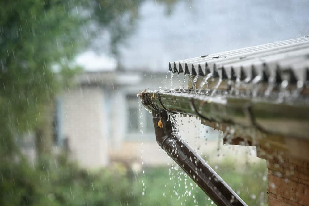 Rain running off a roof top into gutters.