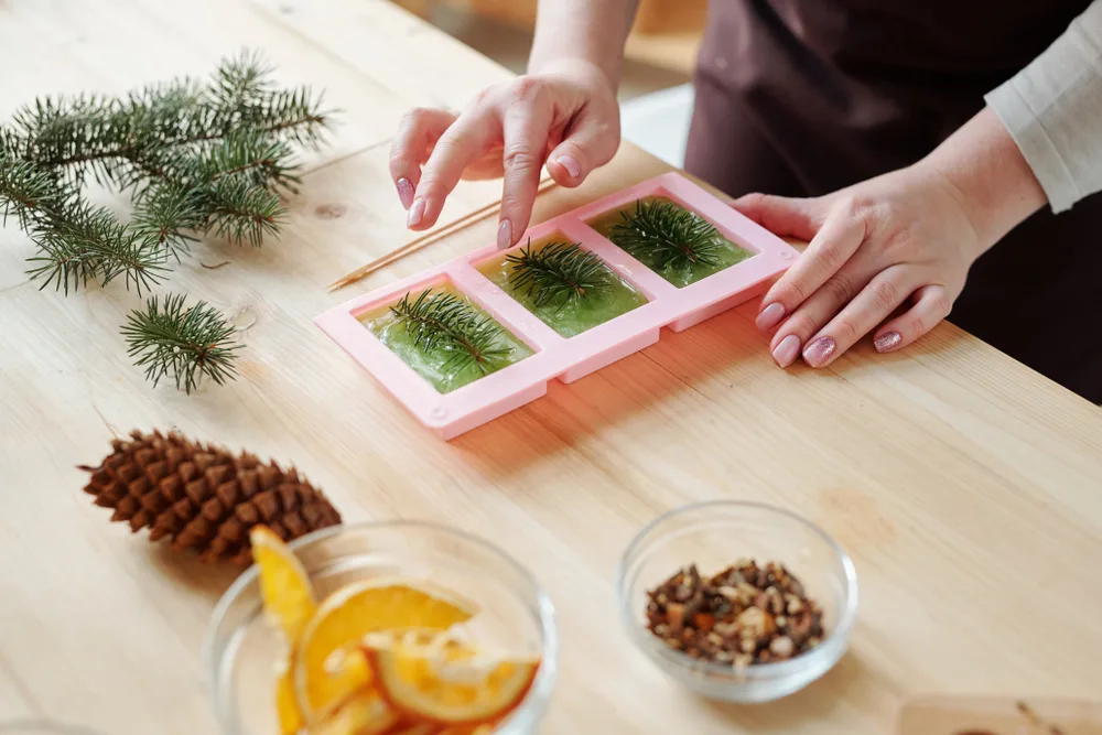 Pushing pine needles into a melted soap base