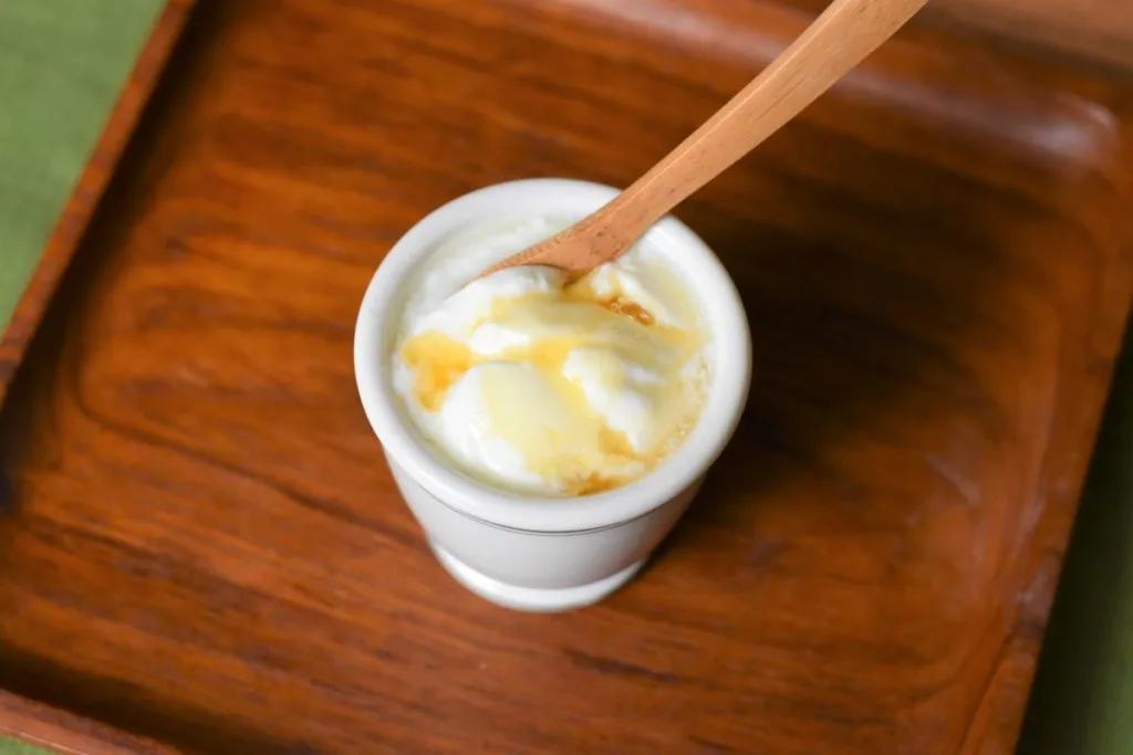 A small dish of yogurt drizzled with honey.