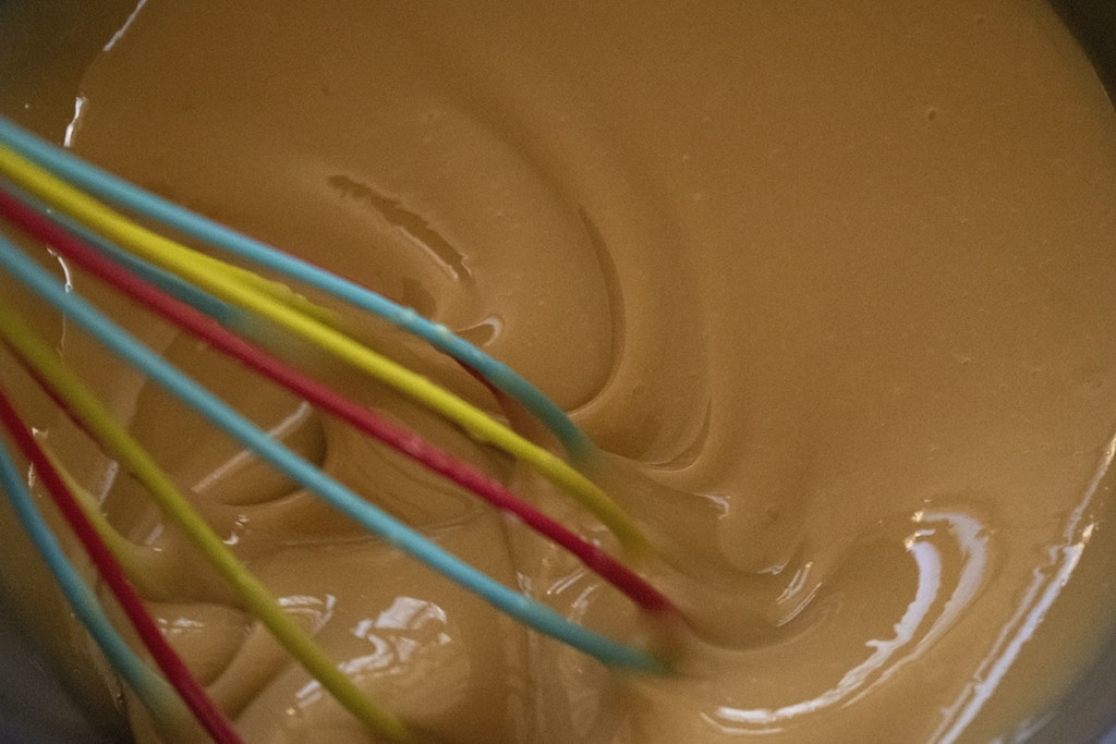 A whisk immersed in maple cream.