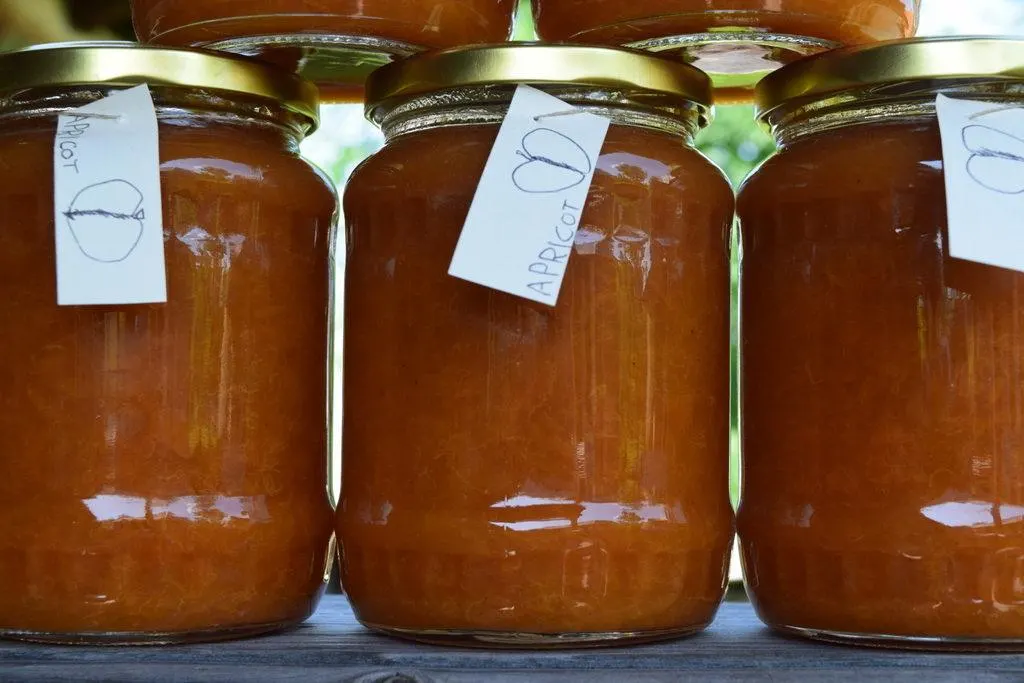 Stacked jars of homemade apricot jam.
