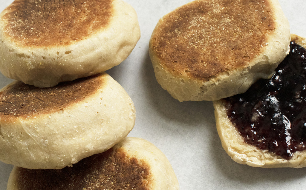 English muffins, one is split and toasted with jam on top.