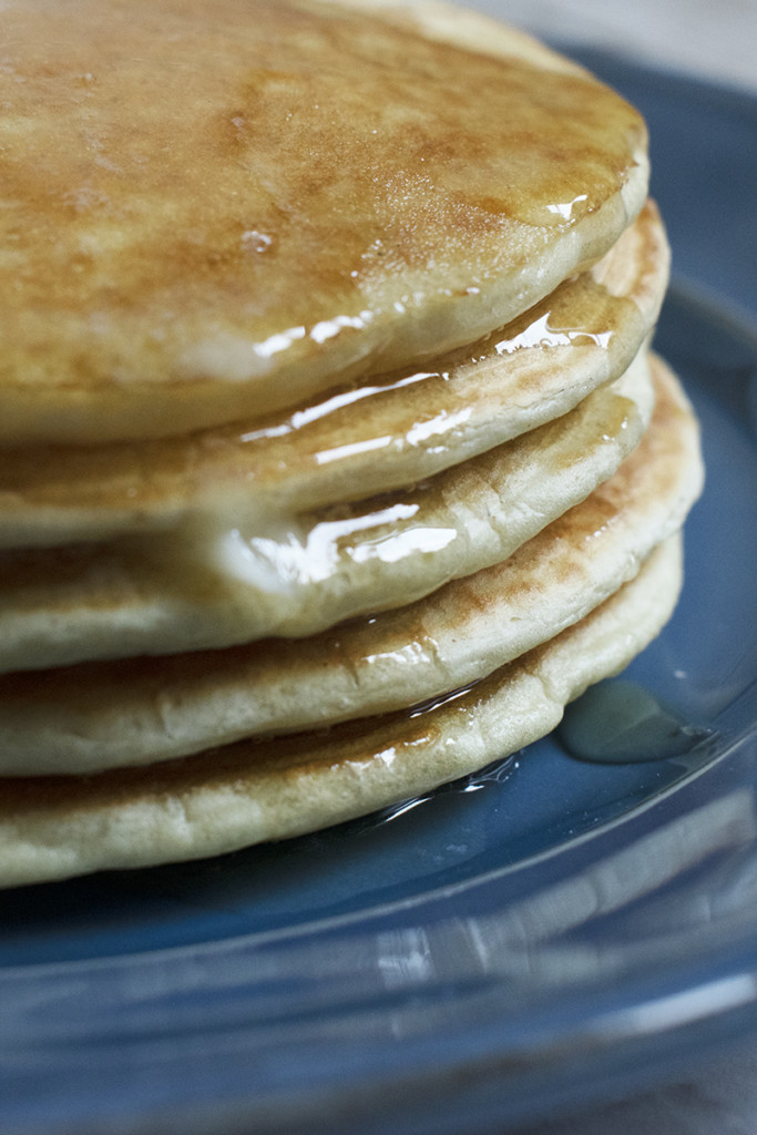 Close up of stack of pancakes on a blue plate.