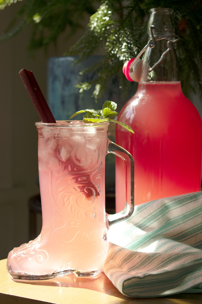 A glass in the shape of a cowboy boot filled with pink rhubarb lemonade
