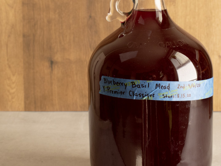 a carboy with a label that read blueberry basil mead