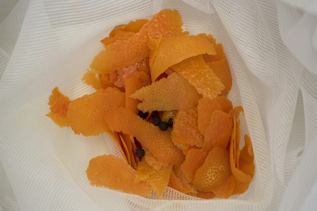 Orange peels and peppercorns are placed in a straining bag. 