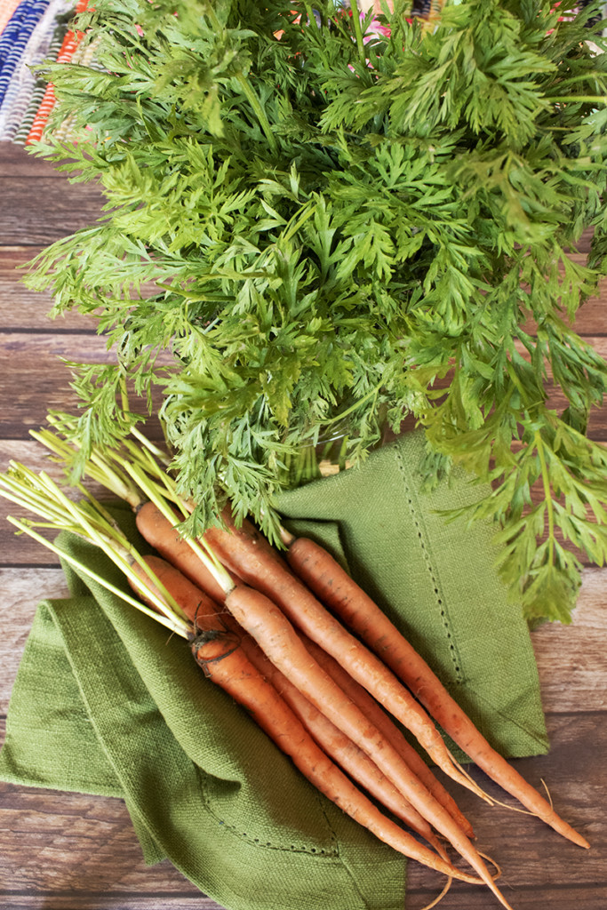 Carrots with carrot tops in jar.