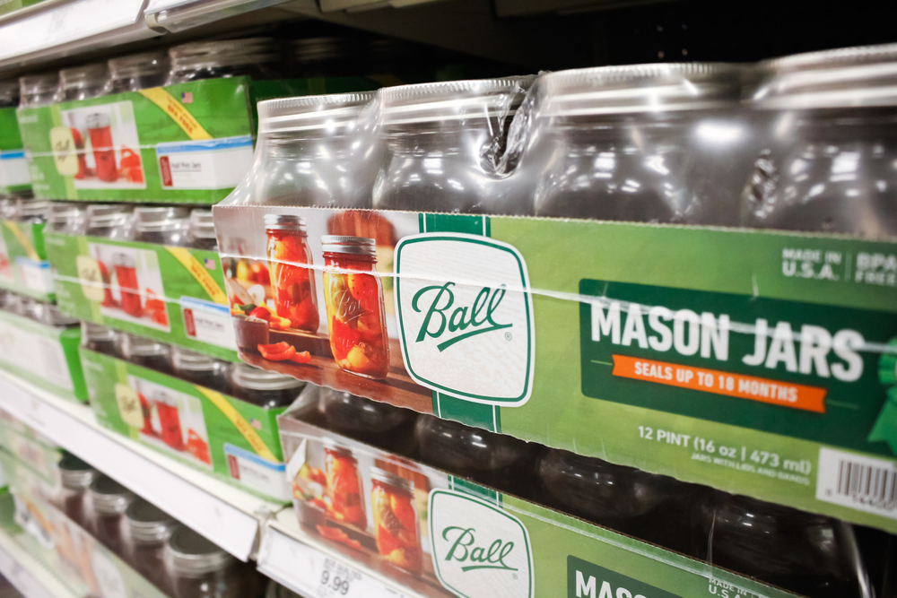 Cases of canning jars on the shelves in a grocery store.