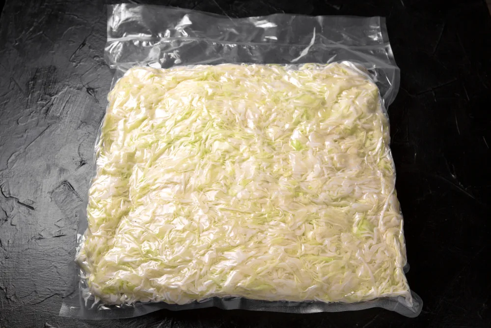 A bag of shredded cabbage sealed in a vacuum bag.