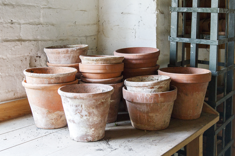 Stacks of aged terracotta pots on a bench.