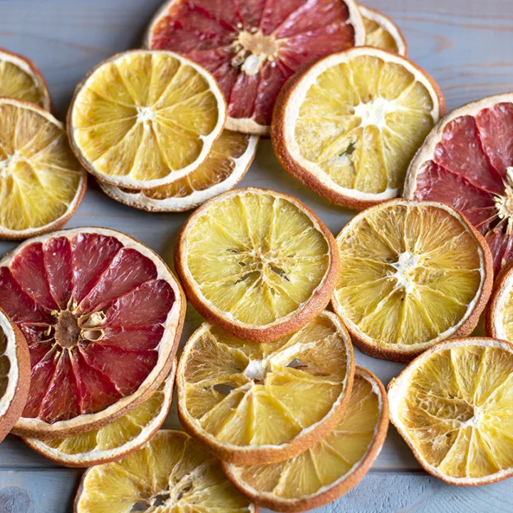 Several citrus slices are spread out on a wooden background.