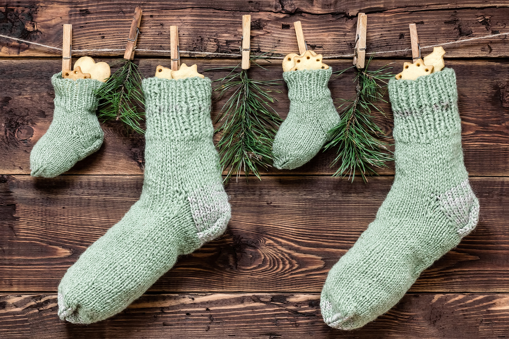 Four handknit stockings hung on a piece of twine with wooden clothespins