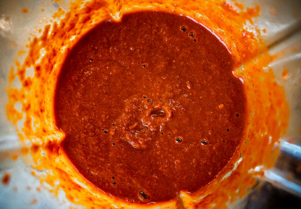 Close up of blended pizza sauce in a blender jar.