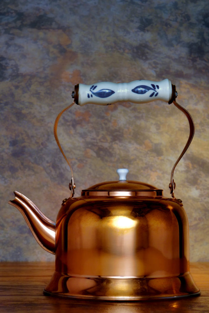A shiny copper kettle.