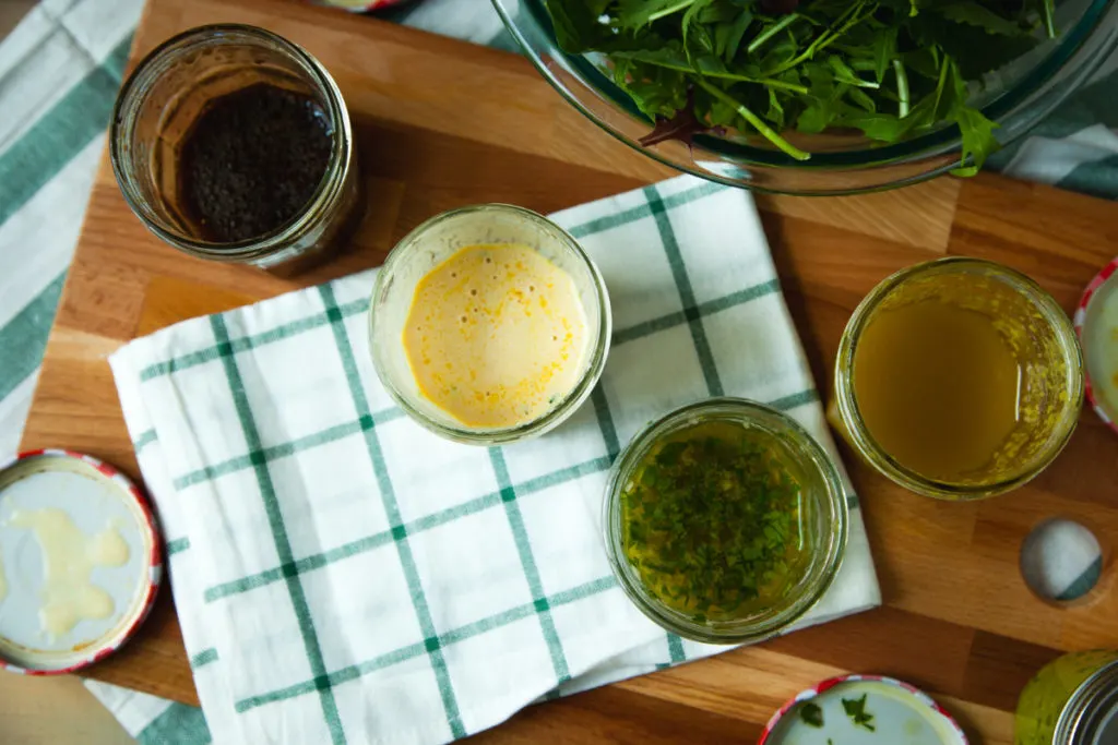 A birds-eye view of several jars of homemade salad dressings.
