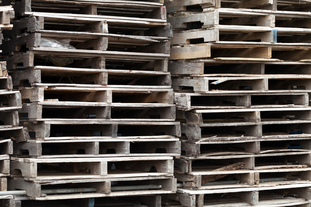 A stack of weather wood pallets.
