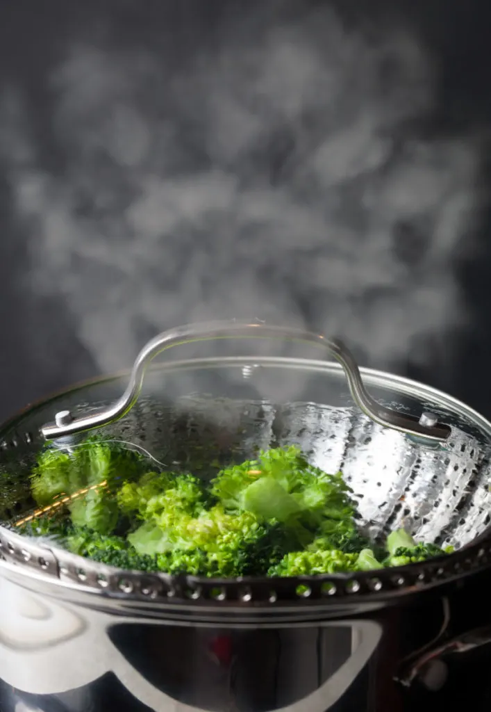 A pot of broccoli being steamed.