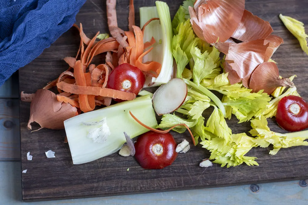 A pile of vegetable scraps on a cutting board.