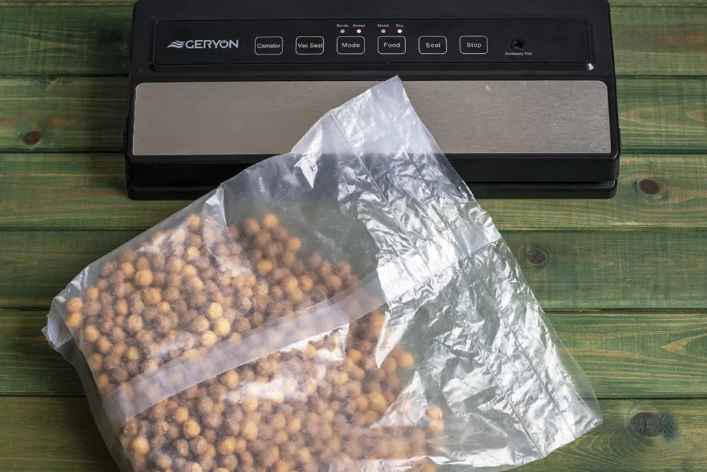 A vacuum sealer with a sealed bag of cereal laying in front of it. 