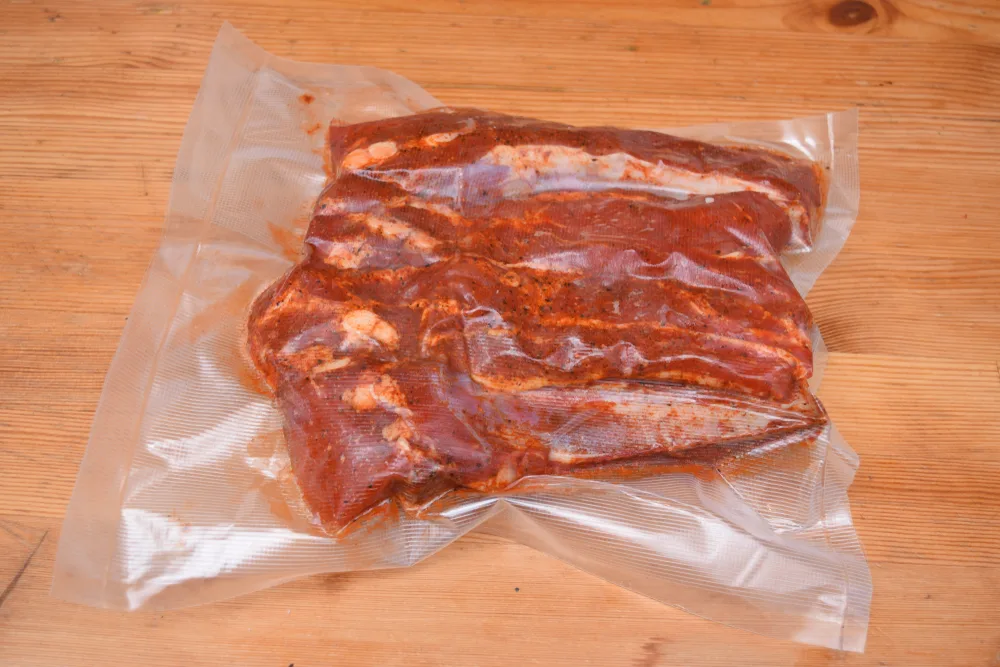 Pork ribs in marinade sealed in a vacuum-sealer food bag.