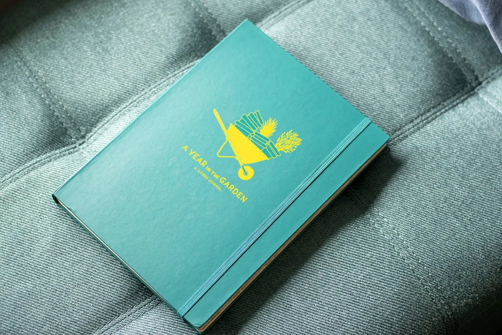 A teal journal called, "A Year in the Garden - a guided journal".
