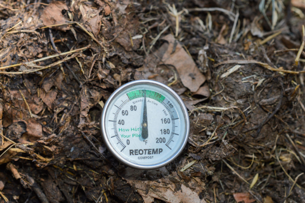 Compost thermometer stuck in a compost heap.