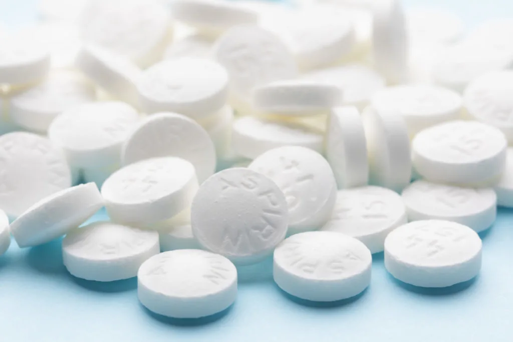 Aspirin tablets on a blue blackground.