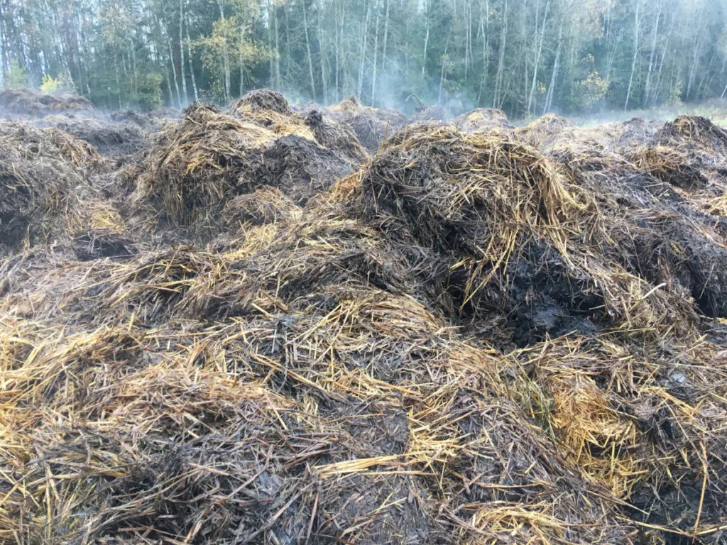 A large area of compost with water vapor coming off of it.