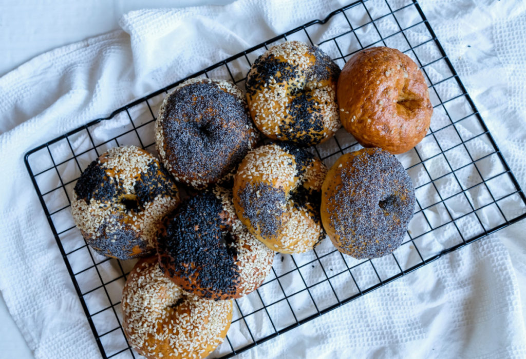 Homemade bagels topped with poppy seeds and sesame seeds.