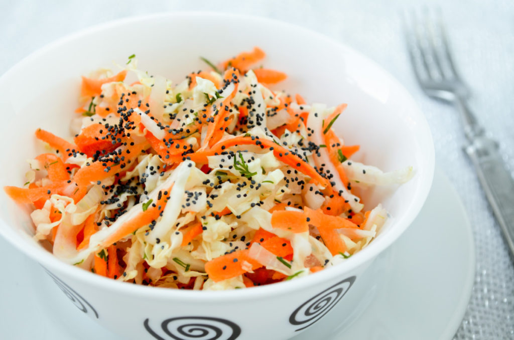 Carrot and poppy seed salad in a white dish.
