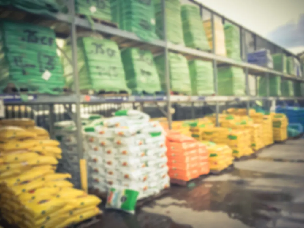 A blurred photo of stacks of potting soil bags. 