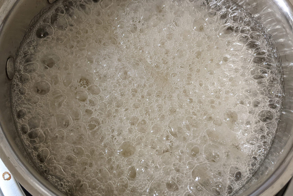 Honey and sugar bubbling in a saucepan to make tea bombs.