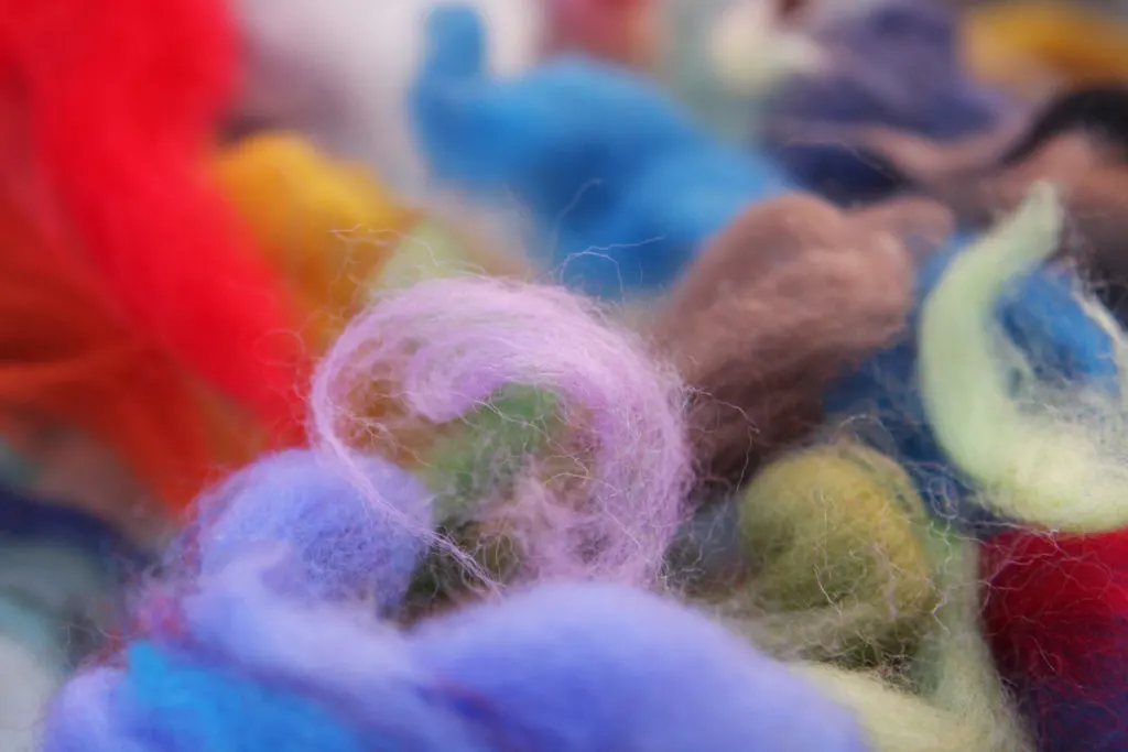Close up of colorful bits of wool used for needle felting.