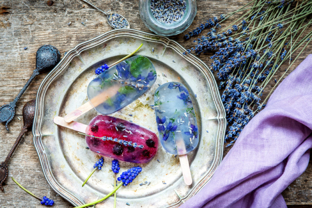 Lavender popsicles with edible flowers frozen inside them.