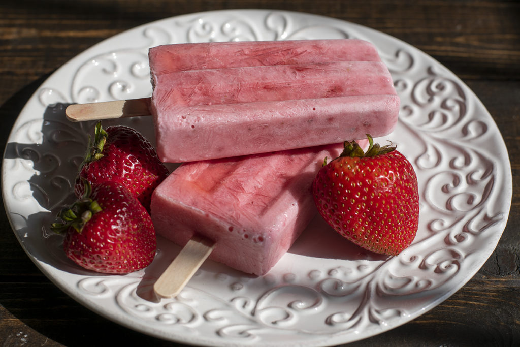 Strawberry popsicles on white plate
