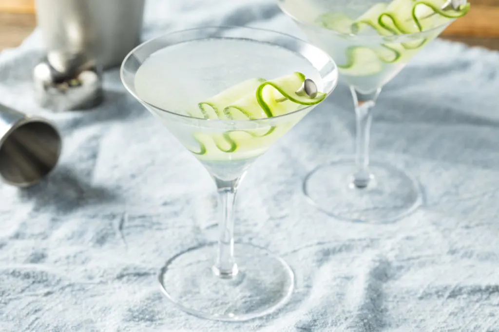 Two martinis with thin slices of cucumber for the garnish.