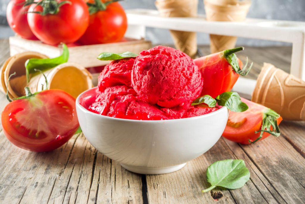 Bright red tomato ice cream in a white bowl