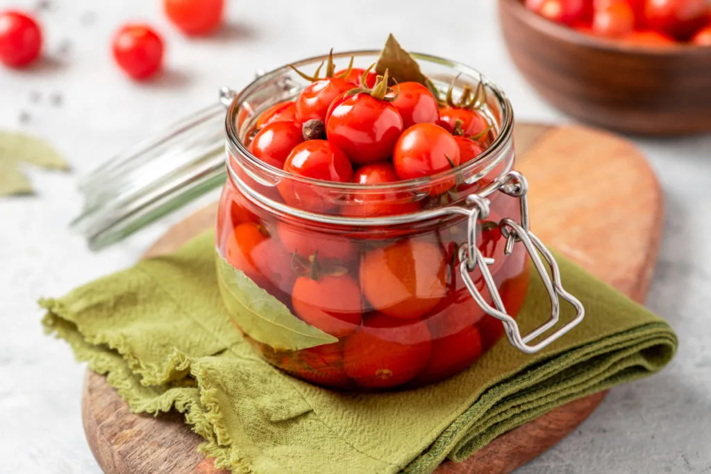 A jar of pickled red cherry tomatoes
