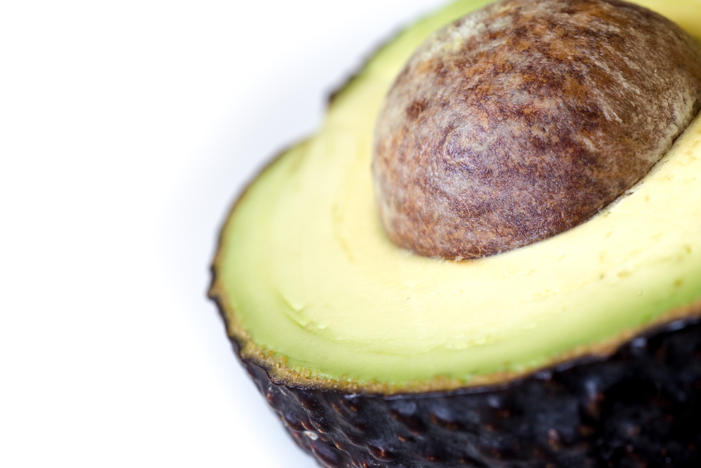Close up of an avocado half with the seed in it. 