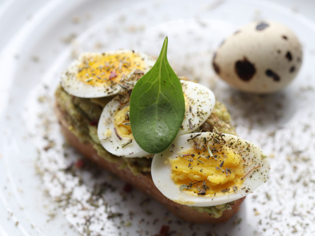 Fancy hard-boiled quail eggs on top of avocado toast.