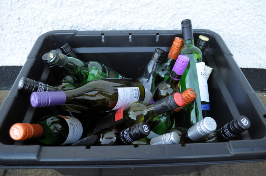 Recycling bin filled with empty wine bottles