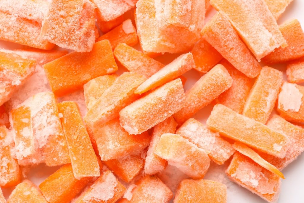 Chopped up frozen carrot pieces.