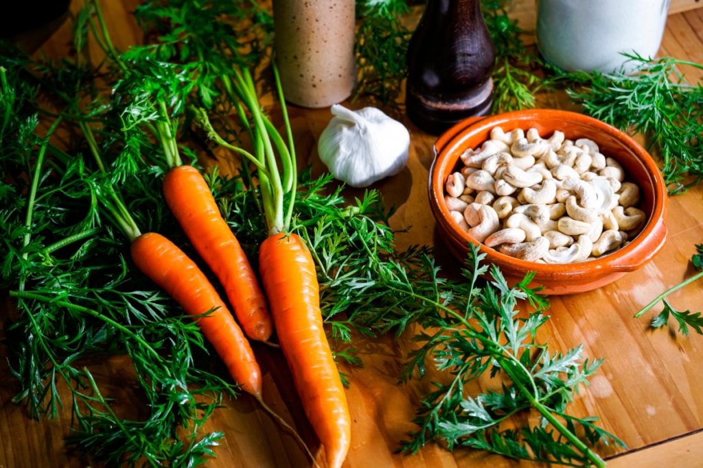 The ingredients for carrot top pesto are laid out on a cutting board. 