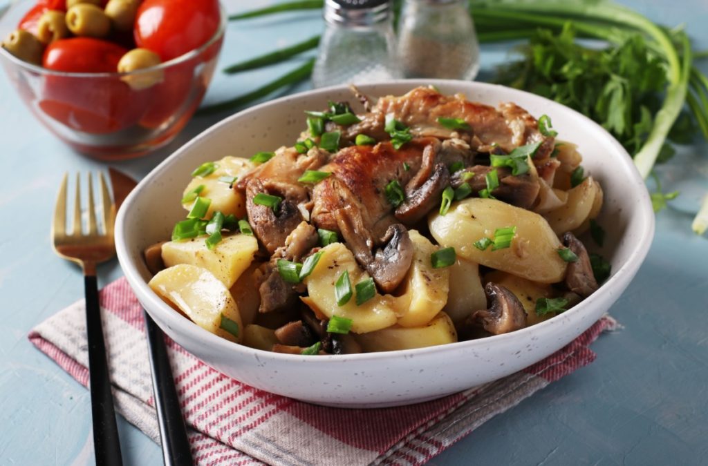 a dish of cooked rabbit, potatoes and mushrooms.