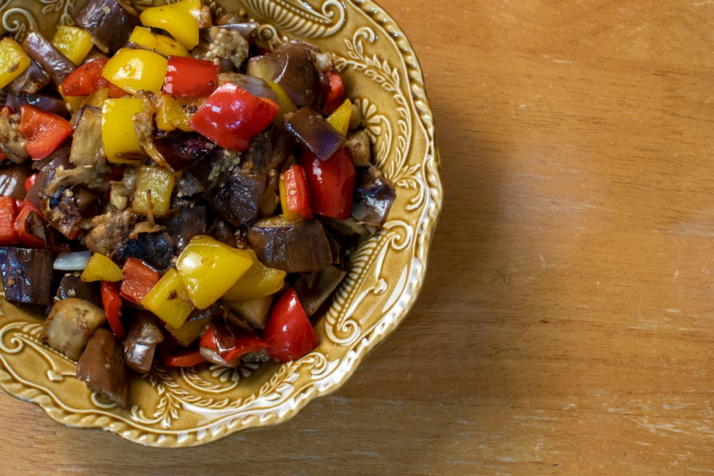 A serving bowl with the cooked eggplant and peppers.