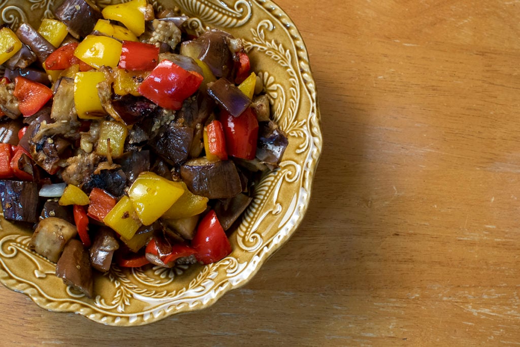 A serving bowl with the cooked eggplant and peppers. 