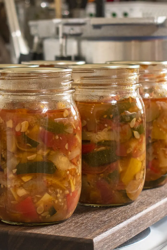 Close up of jars of ratatouille on a cutting board. 