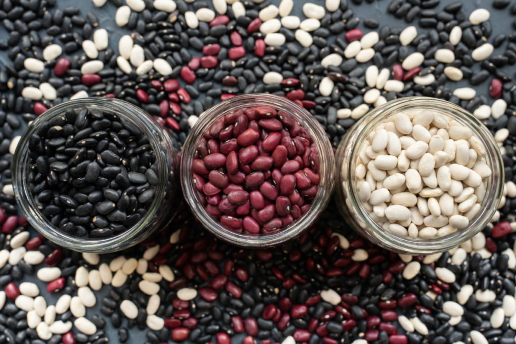Overhead view of jars of black beans, kidney beans and navy beans