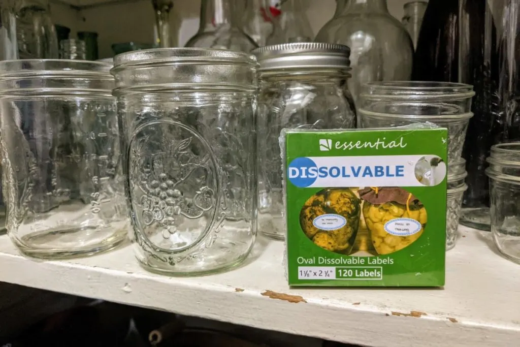 mason jars on a shelf with a box of dissolvable labels 